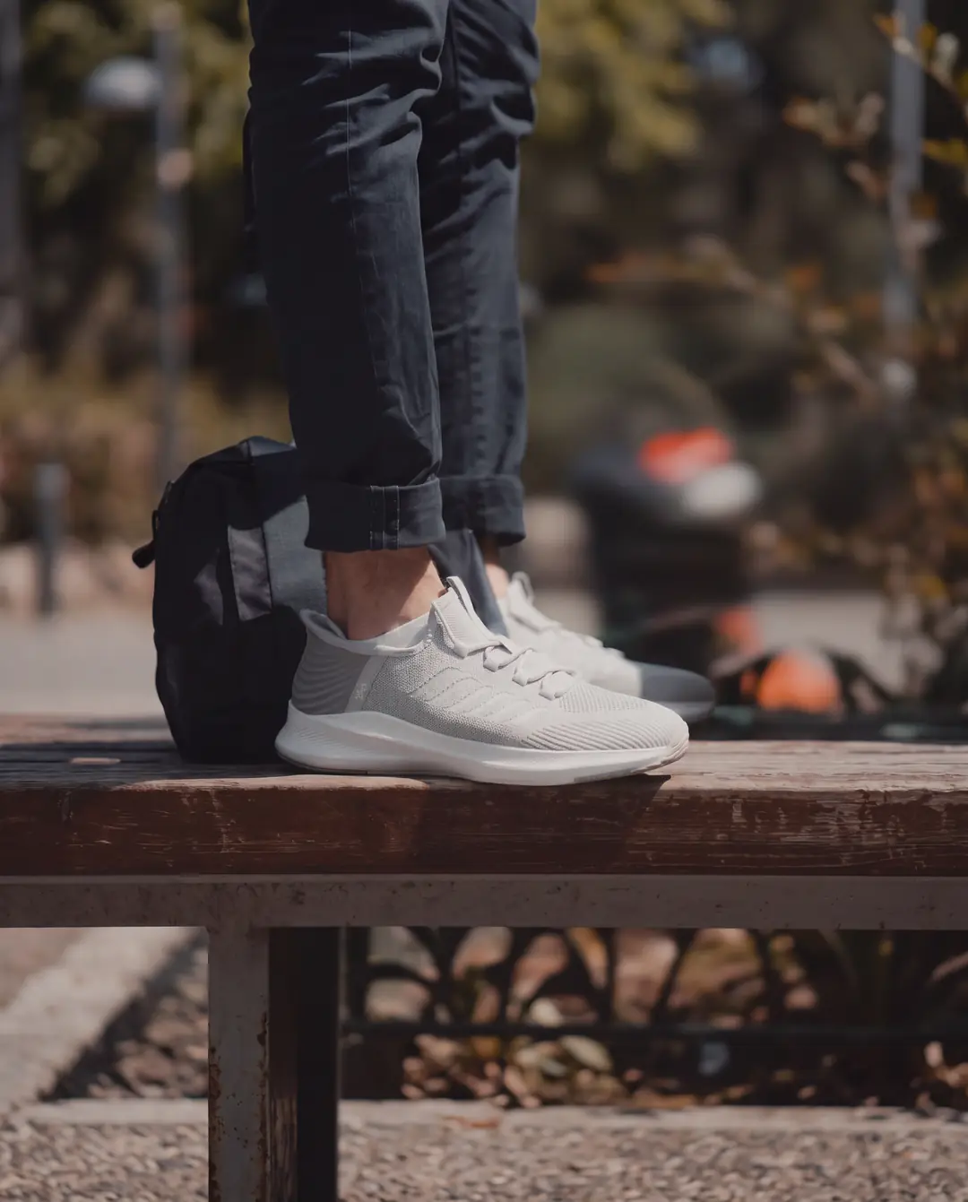 Basket blanche Slick portee en exterieur, posee sur un banc en bois.